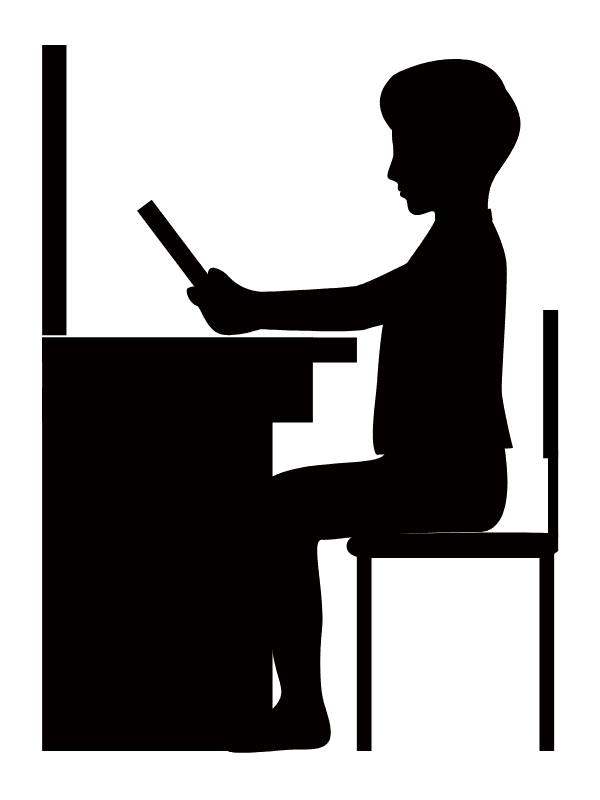 机に向かって本を読む子ども