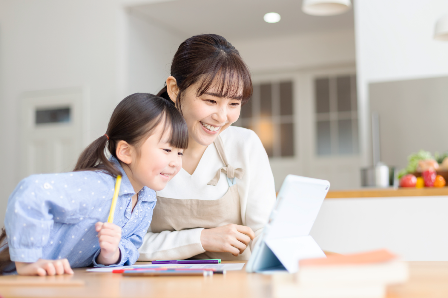 親子がタブレットをのぞき込んでいる写真